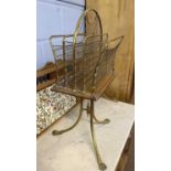 A late 19th or early 20th Century brass and oak revolving magazine rack with meshed four section top