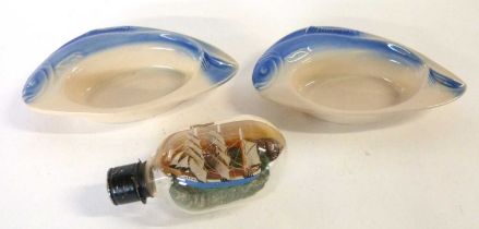 Two Art Deco dishes, the rims modelled as fish by Charles Amand and a small ship in a bottle