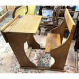 A mid 20th Century golden oak school desk, unusual feature as the seat is attached to the desk,