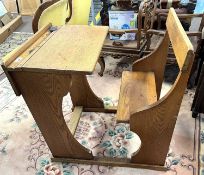 A mid 20th Century golden oak school desk, unusual feature as the seat is attached to the desk,