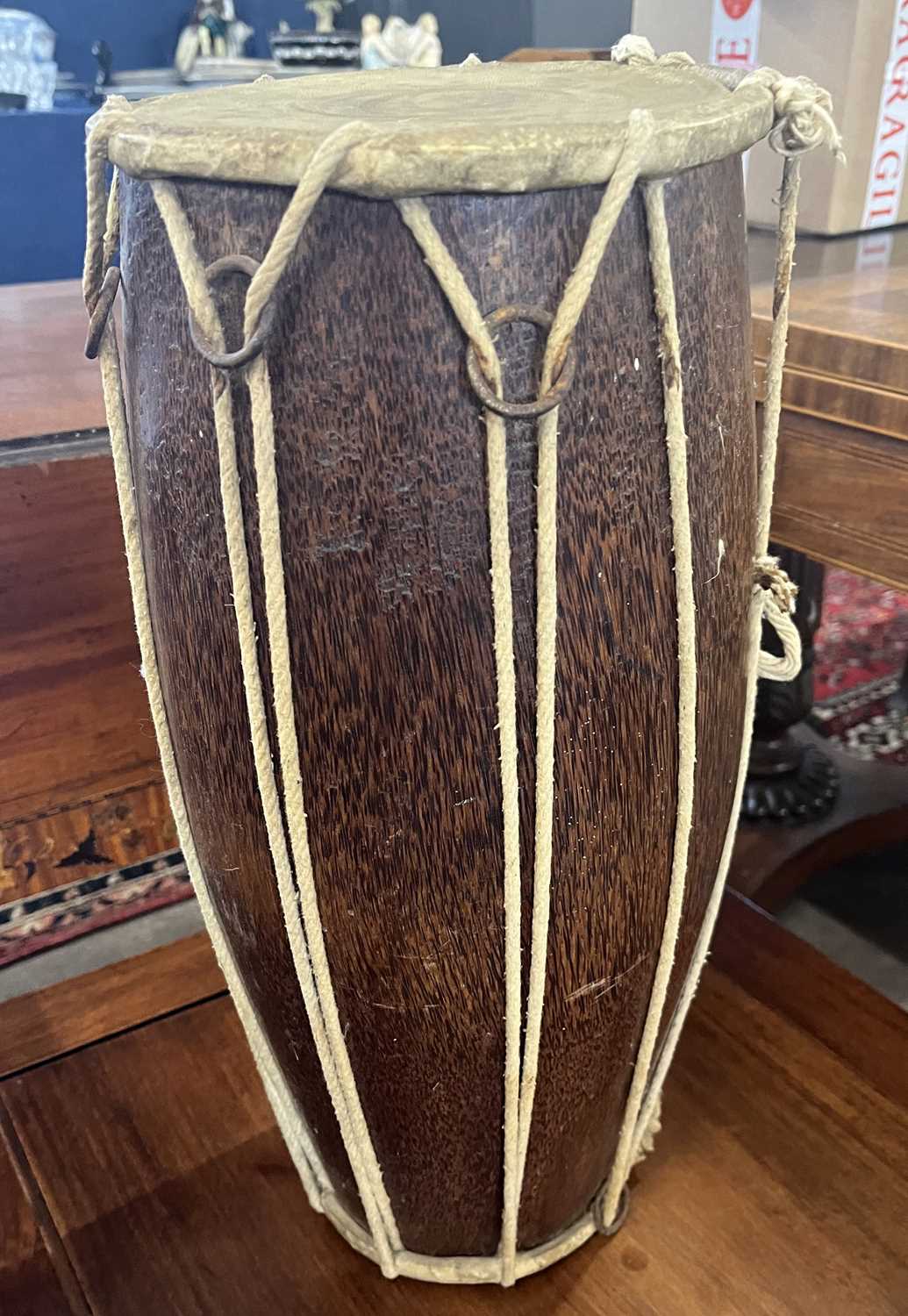 A small hide covered hardwood double ended drum, 25cm high