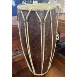 A small hide covered hardwood double ended drum, 25cm high