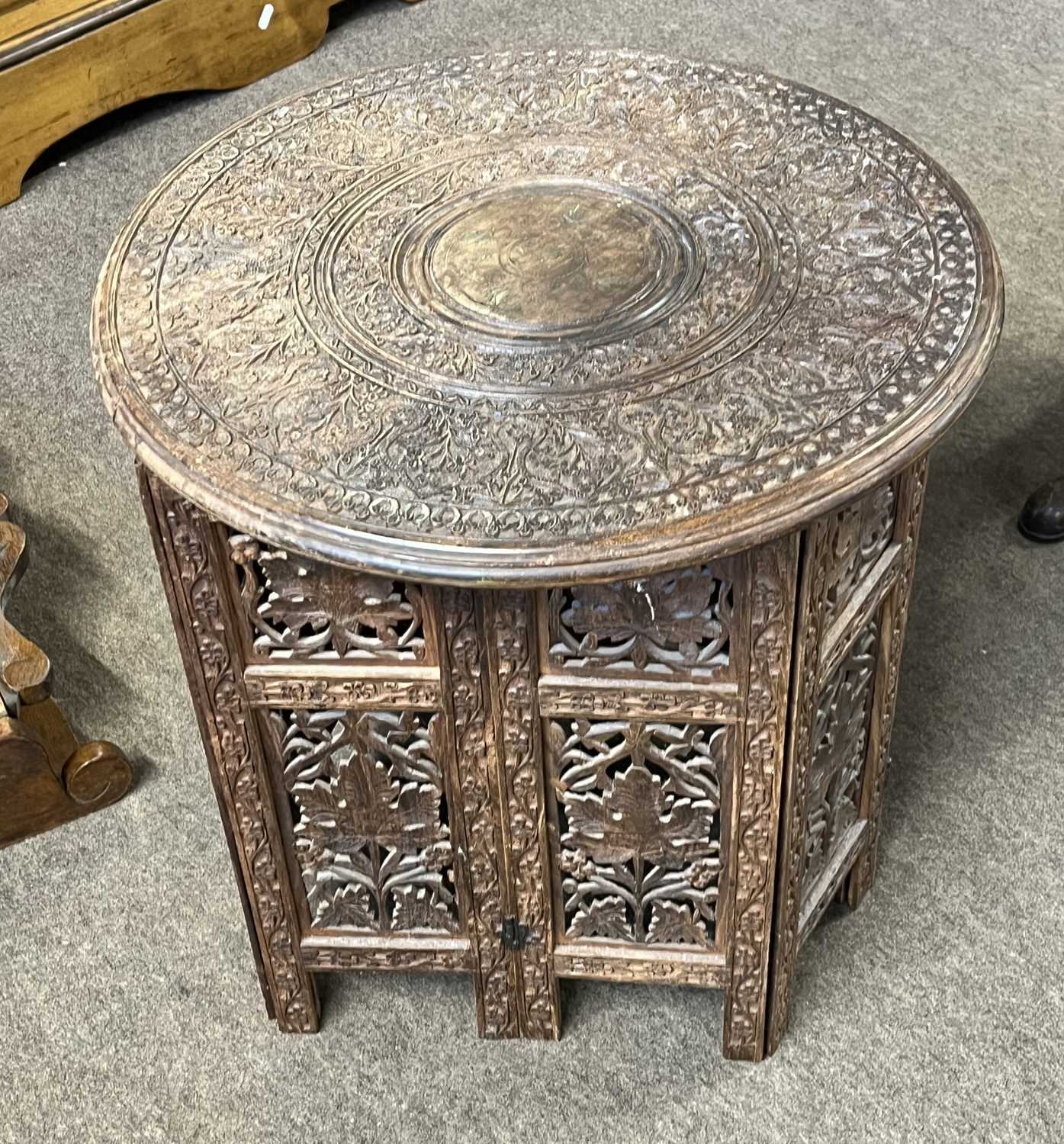 An Indian hardwood occasional table with carved circular top and pierced folding base, top 45cm - Image 3 of 3