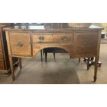 An Edwardian mahogany bow front sideboard in the Georgian style fitted with one shallow and one deep