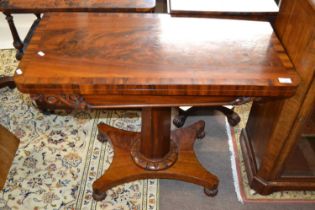 A Victorian flame mahogany veneered card table with folding and rotating baize lined top over an