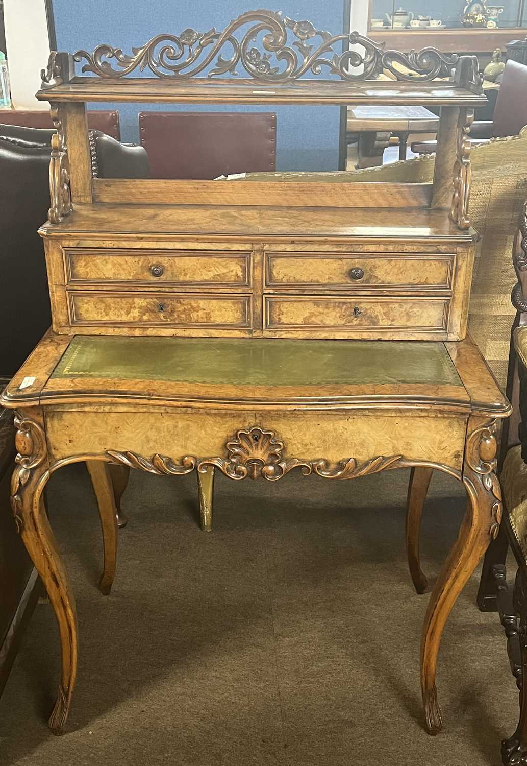 A Victorian walnut veneered ladies writing desk with galleried shelf over four drawers, a tooled