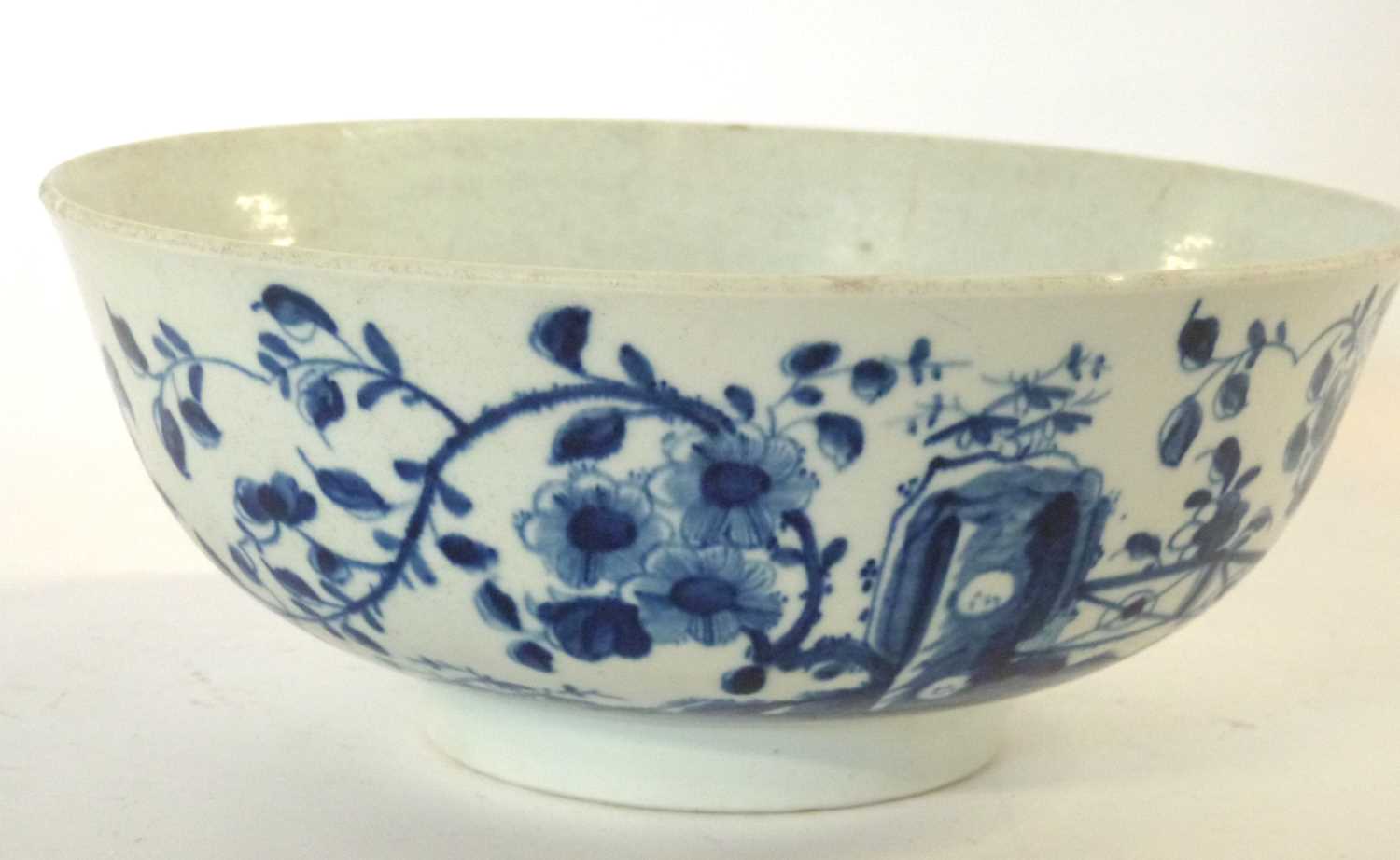 An early Worcester porcelain punch bowl with the prunus fence decoration and workmans mark to