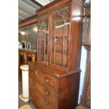 A George III mahogany secretaire cabinet with moulded cornice over two glazed doors and a base