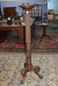 Mahogany torchere stand with circular top over a ribbed column raised on three outswept legs with