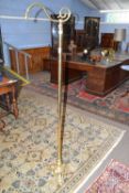 Brass standard lamp with three footed base, plain column and a scroll top, (lacking shade), 172cm