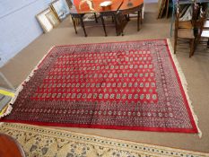 Large 20th century Middle Eastern red ground floor rug decorated with a large central panel of