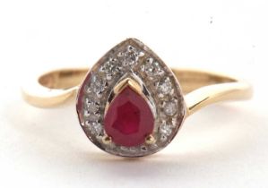 A 9ct ruby and diamond ring, the central pear shape ruby, claw mounted and surrounded by small round