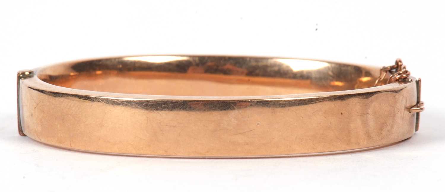 A 9ct hinged bangle, the 9mm wide bangle with engraved decoration to upper half and plain lower - Image 2 of 3