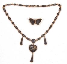 A Japanese Damascene necklace and brooch, comprised of black discs with bi-colour metal inlay,