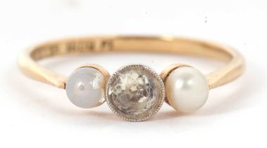 An 18ct three stone ring, set with a central white stone with a cultured pearl to either side,