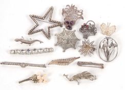 A group of silver and white metal brooches, to include an amethyst and marcasite brooch, a silver
