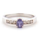 A 9ct tanzanite and diamond ring, the central oval tanzanite in a four claw mount, with diamond
