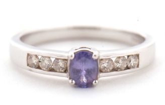 A 9ct tanzanite and diamond ring, the central oval tanzanite in a four claw mount, with diamond