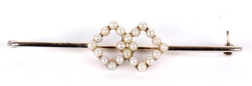 An 18ct seed pearl bar brooch, set to centre with two interlocked diamond shapes set with seed