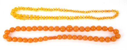 Two amber bead necklaces, the first with round beads approx. 13 - 19mm diameter, 65cm long, 80g,