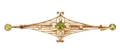 A 15ct peridot and seed pearl bar brooch, set to centre with a round peridot and four seed pearls on