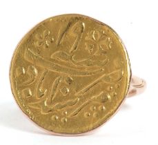 A Middle Eastern coin ring, the coin with a collet mount and plain band stamped 9ct, size L, 5.0g