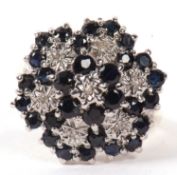 A 9ct sapphire and diamond cluster ring, the flowerhead design set with illusion set diamonds and