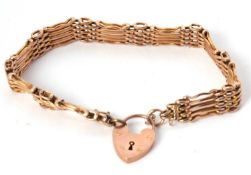 A 9ct gate bracelet, 10mm wide, with integrated tag stamped 9ct, with heart shaped padlock clasp