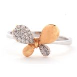 A two tone 18ct diamond butterfly ring, the wings alternately diamond pave and rose gold, to a plain