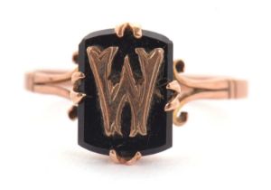 A 9ct ring, the black onyx plaque with intial W to front, split shoulders and plain band stamped
