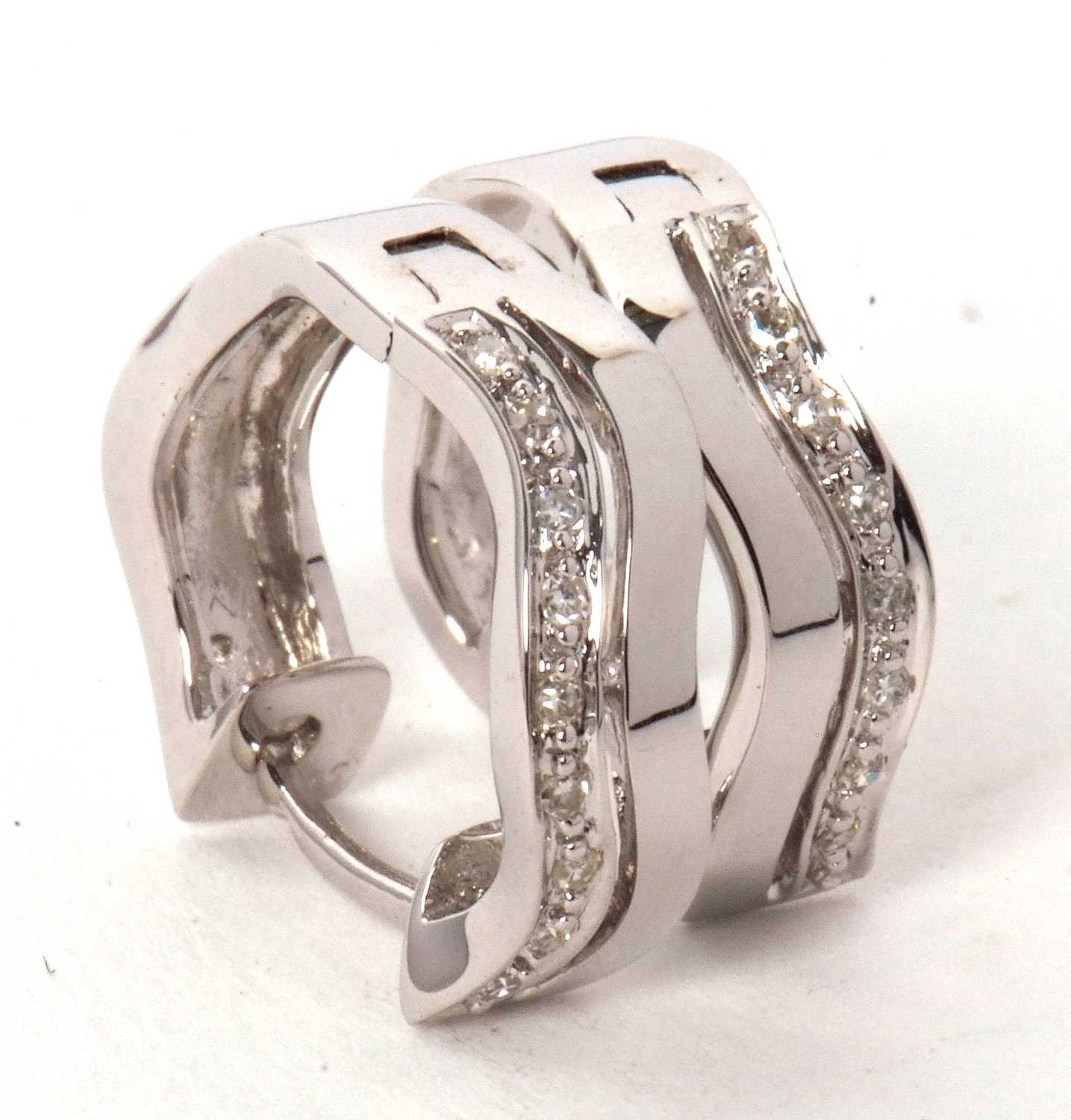 A pair of 9ct and diamond earrings, the hoops set with two undulating lines, one set with small