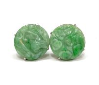 A pair of Jade earrings of circular form, carved with a foliate design. Four claw set in a