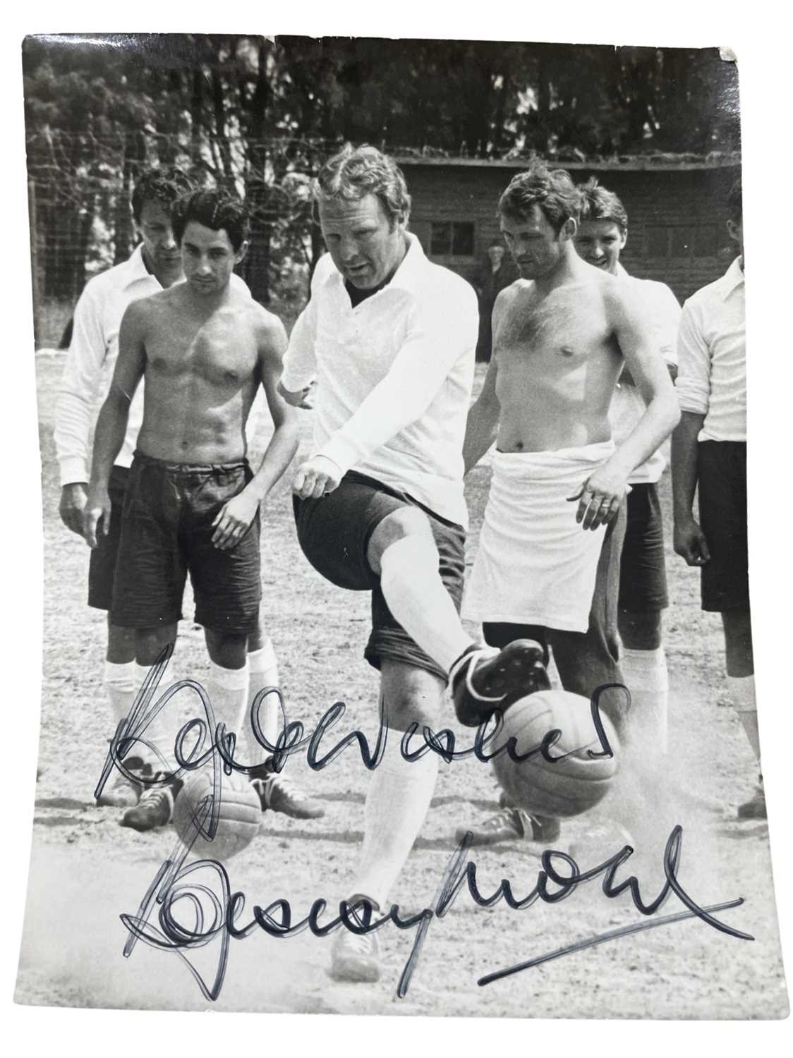 A black and white photograph bearing the signature of the late Sir Bobby Moore in black ink (