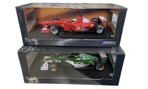 A pair of boxed Hotwheels 1:18 scale model racing cars, to include: - F1-2000, Rubens