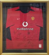 A framed and glazed Manchester United shirt, bearing the signatures of the 2003-2004 team.