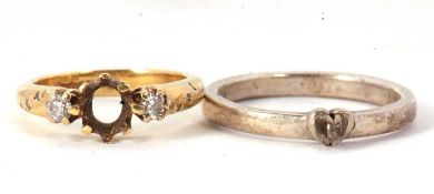 An 18ct ring and silver ring, the 18ct ring set with two round diamonds (centre stone missing),