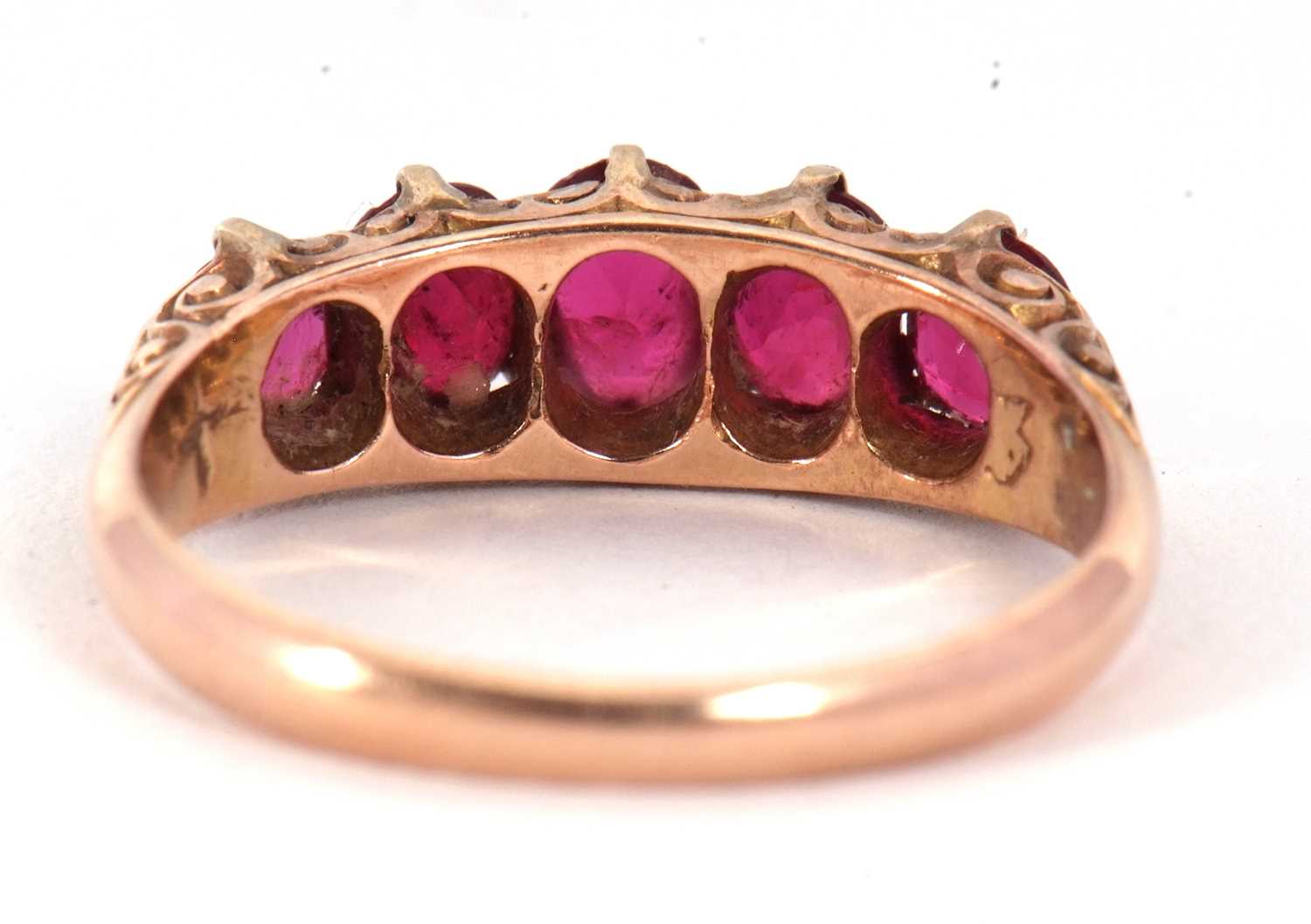 A five stone ruby ring, the five graduated rubies all claw mounted with a scrolled gallery and - Image 6 of 7