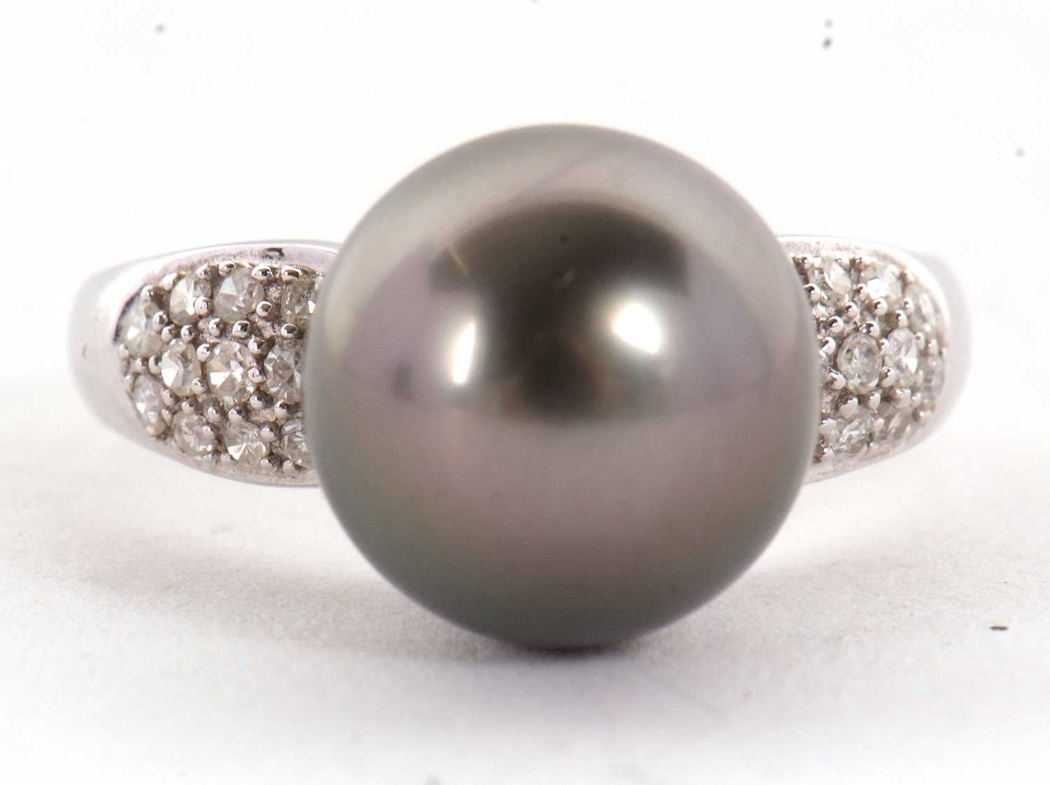 An 18ct cultured black pearl and diamond ring, the round black cultured pearl, approx. 11.5mm
