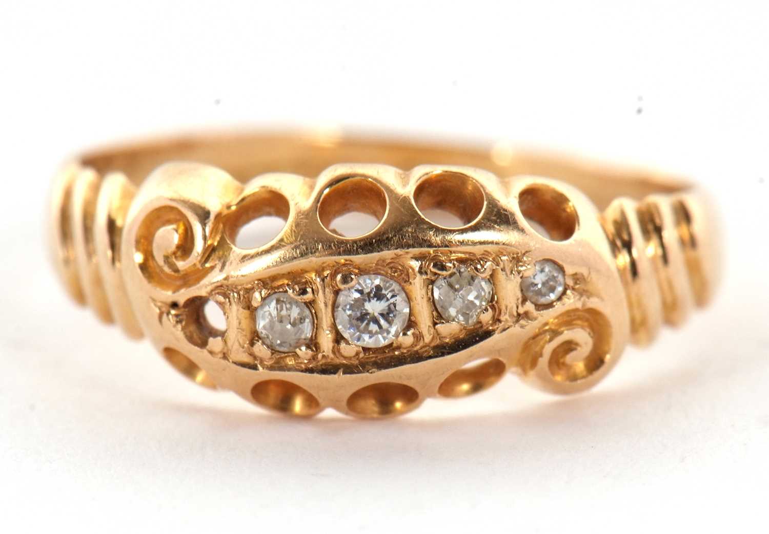 A diamond ring, set with small round diamonds (one missing), with pierced gallery and ridged