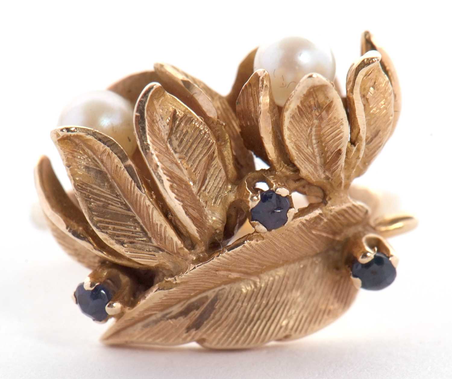A cultured pearl and sapphire floral ring, the two flowers set with a round cultured pearl to