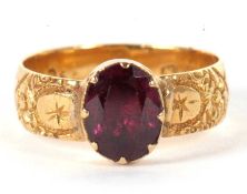 A garnet ring, the oval collet and claw mounted garnet with closed back, with 5.4mm wide band with