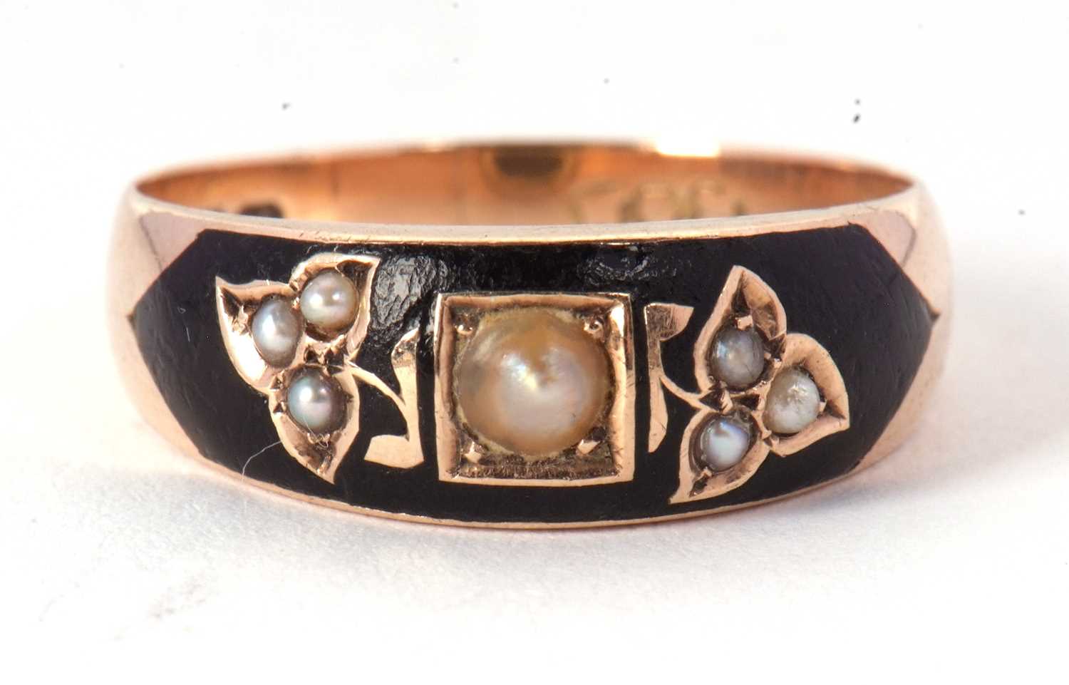 An early 20th century black enamel and seed pearl ring, the tapered black enamel set with seed