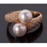 An 18ct cultured pearl and diamond crossover ring, the two cultured pearls set to a half set diamond