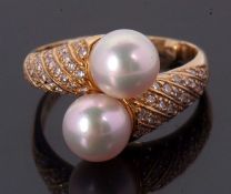 An 18ct cultured pearl and diamond crossover ring, the two cultured pearls set to a half set diamond