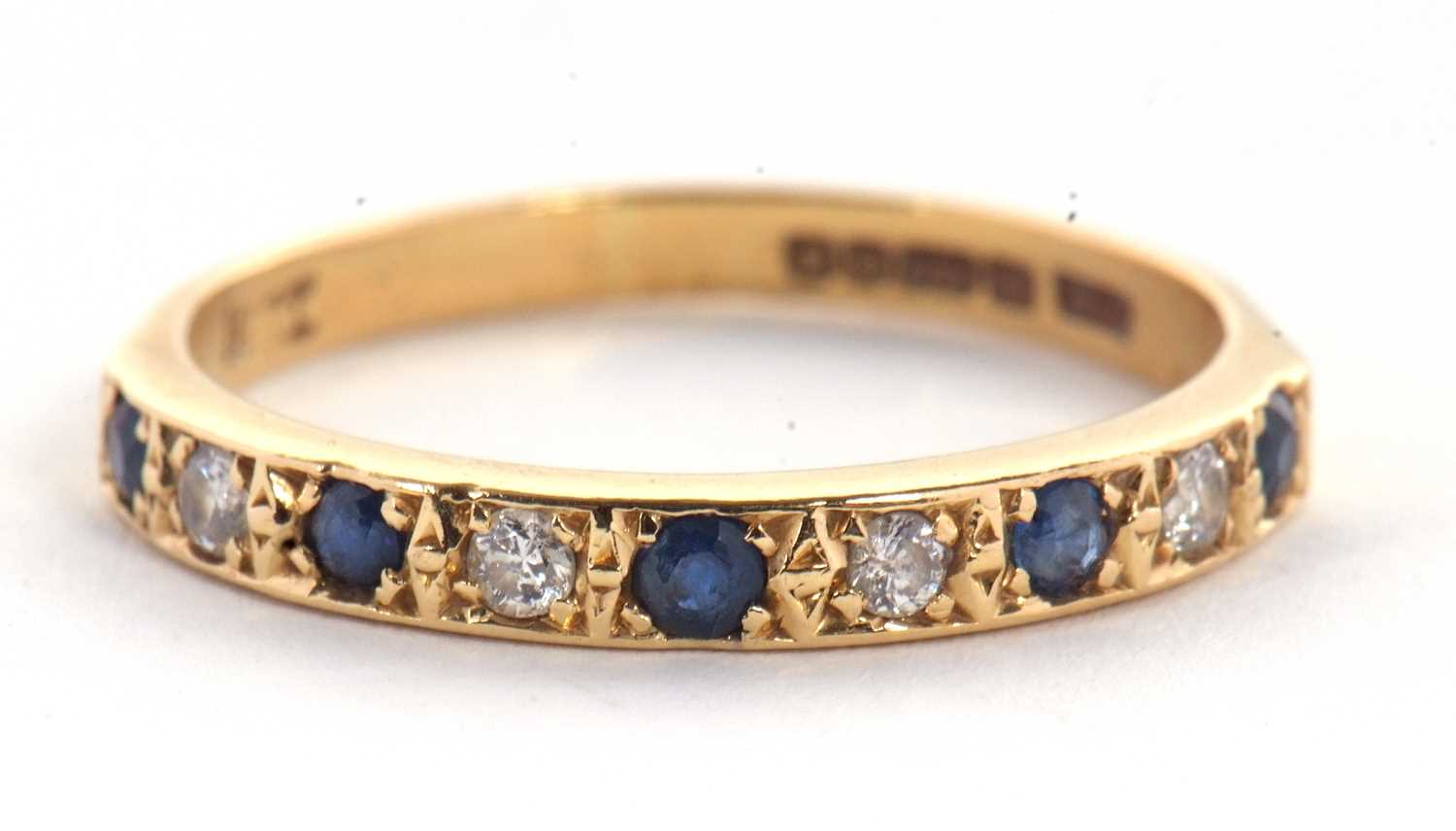 An 18ct sapphire and diamond ring, the half hoop ring set with alternating round sapphires and