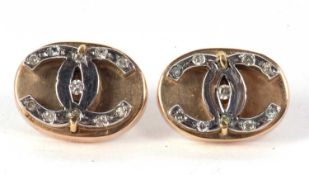 A pair of diamond earrings, the oval discs set with interlocking 'CC' design and set with small