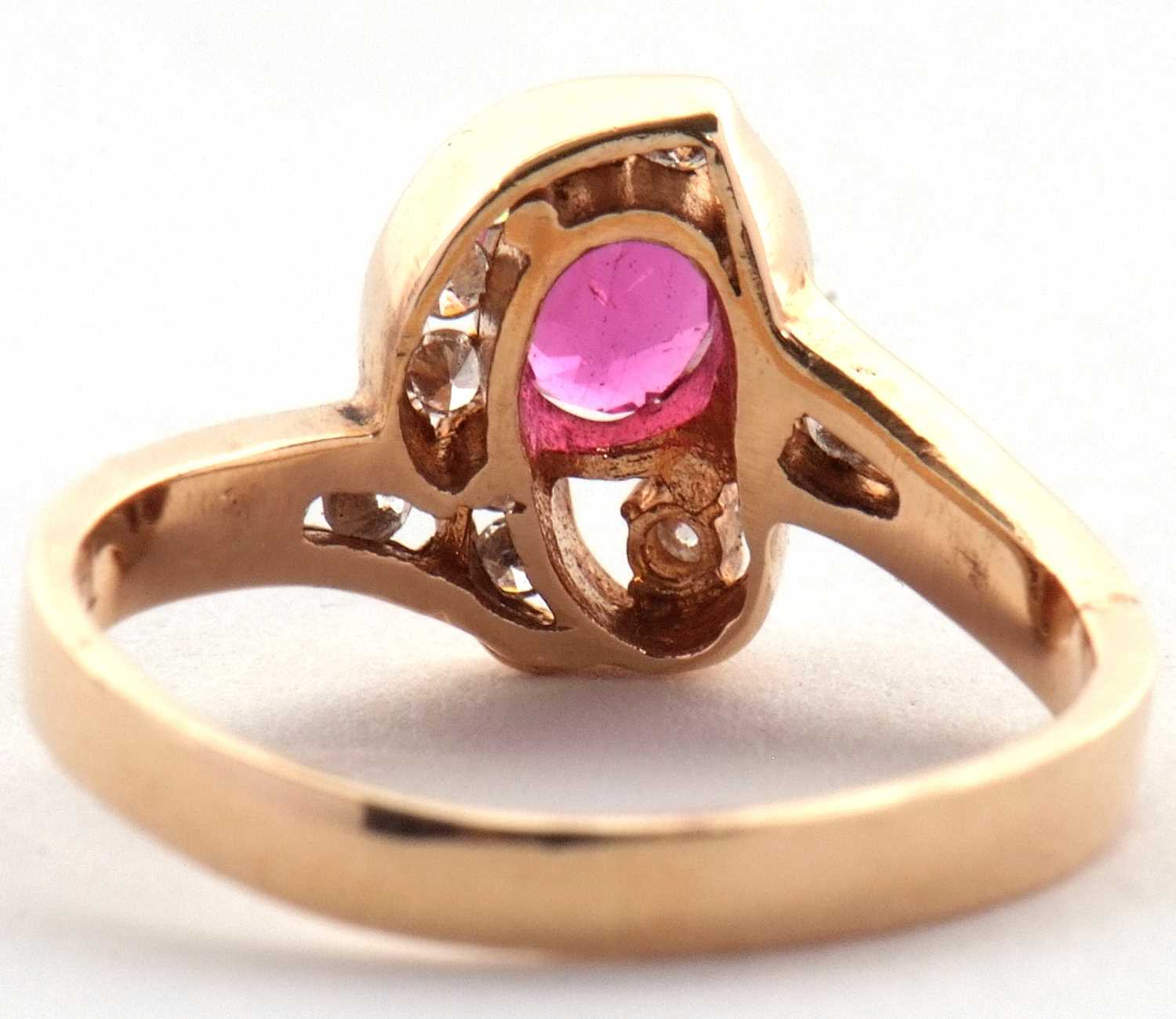 A 14k ruby and diamond ring, the central four claw mounted oval ruby, asymetrically set with small - Image 3 of 4