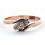 A 9ct diamond ring, the three small round diamonds, illusion mounted in a crossover band of rose
