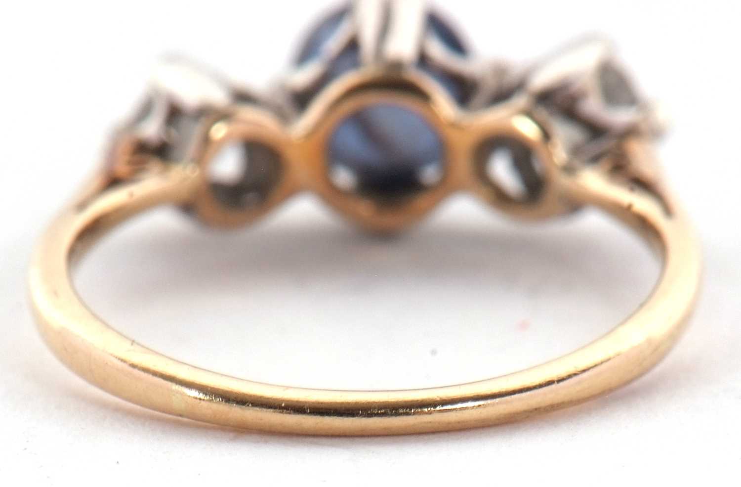 A sapphire and diamond ring, the round mixed cut sapphire set to either side with a round - Image 6 of 7