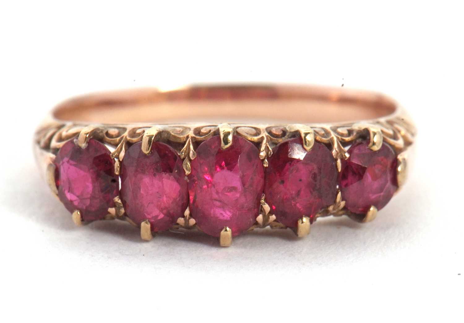 A five stone ruby ring, the five graduated rubies all claw mounted with a scrolled gallery and